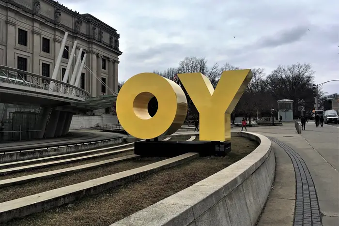 A photo of the Yo/Oy sign in from of Brooklyn Museum